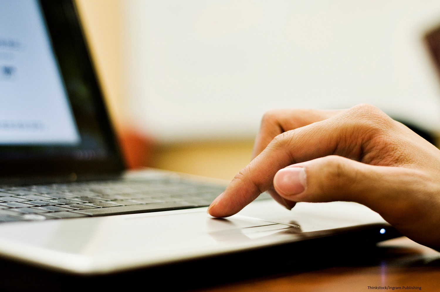 Student's finger on trackpad of computer.